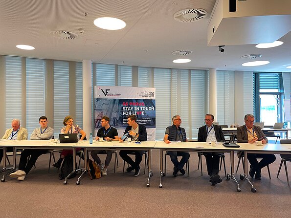 Teilnehmer sitzen an Konferenztischen während einer Veranstaltung von VF Alumni + Friends Esslingen University in einem Seminarraum.