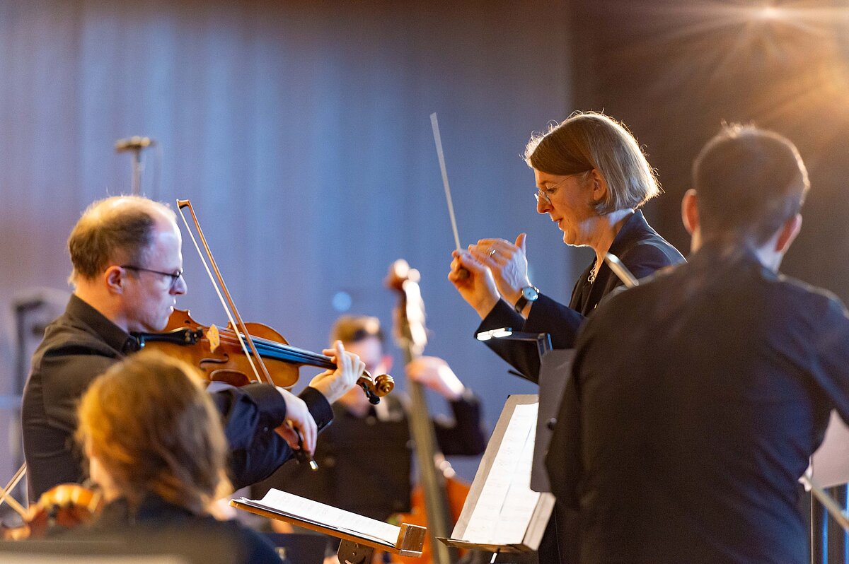 Orchesterszene des Matineekonzerts des VdF Alumni + Friends mit Dirigat und spielenden Violinen.